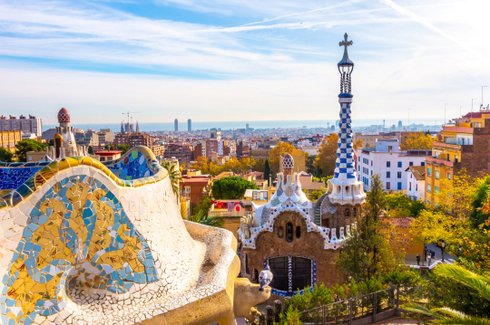 Blick &uuml;ber Barcelona mit seiner bunten Architektur, am Horizont das Meer