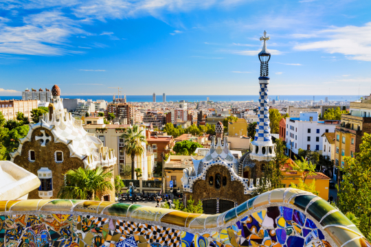 Blick über Barcelona mit seiner bunten Architektur, am Horizont das Meer